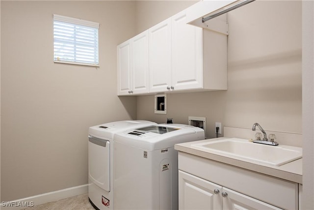 laundry room with washing machine and clothes dryer, sink, and cabinets