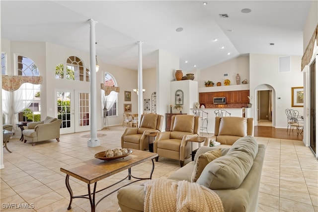 living room with light tile patterned flooring and high vaulted ceiling