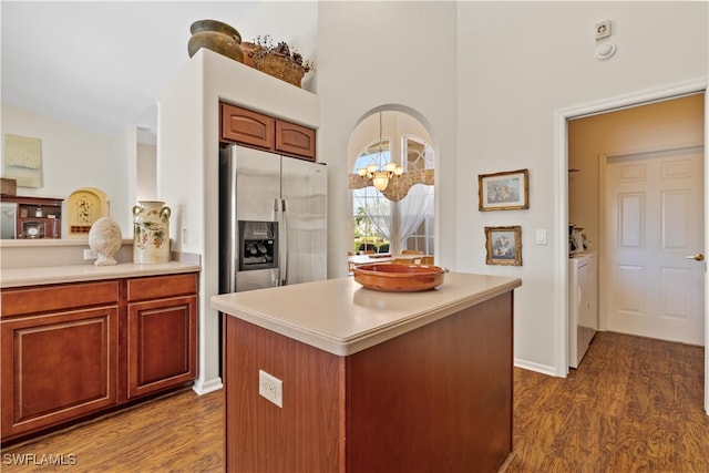 kitchen featuring a center island, dark hardwood / wood-style flooring, stainless steel refrigerator with ice dispenser, independent washer and dryer, and a notable chandelier