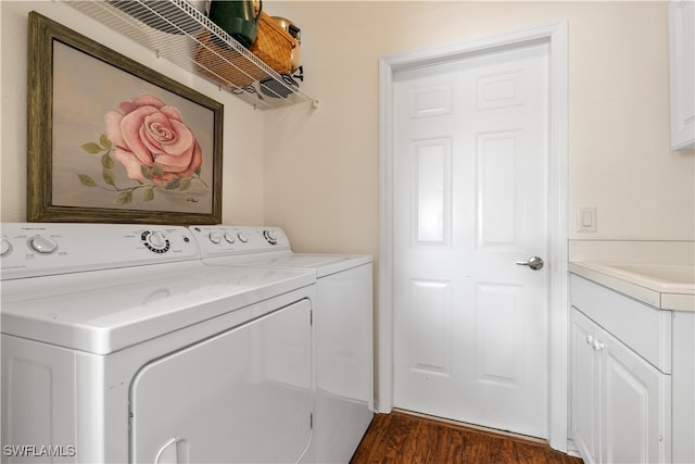 clothes washing area featuring cabinets, dark wood-type flooring, and washing machine and clothes dryer