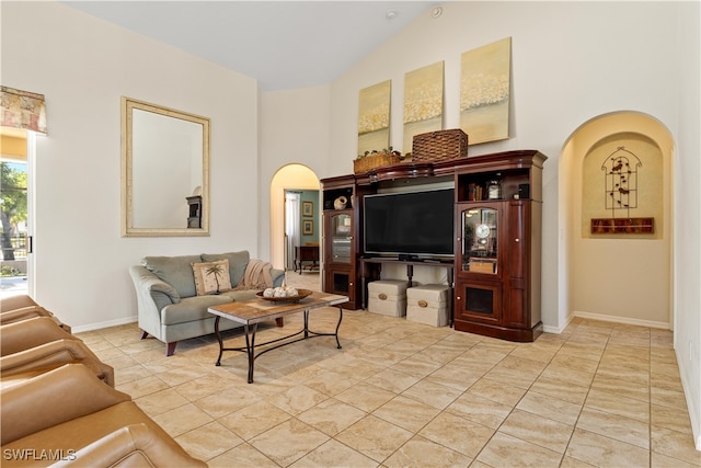 tiled living room featuring high vaulted ceiling