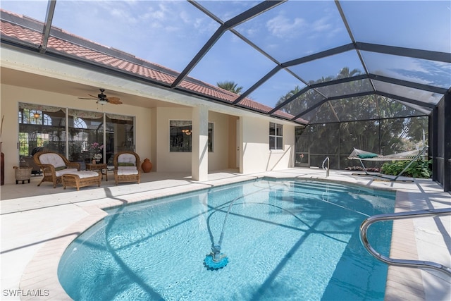 view of swimming pool featuring a lanai, ceiling fan, and a patio