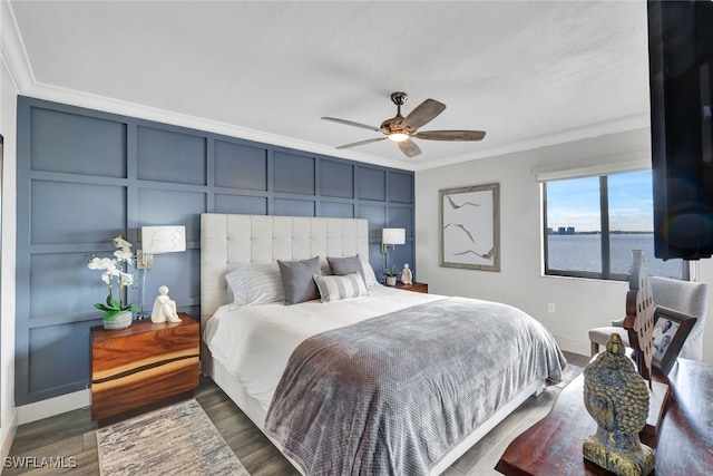 bedroom featuring dark hardwood / wood-style flooring, crown molding, ceiling fan, and a water view