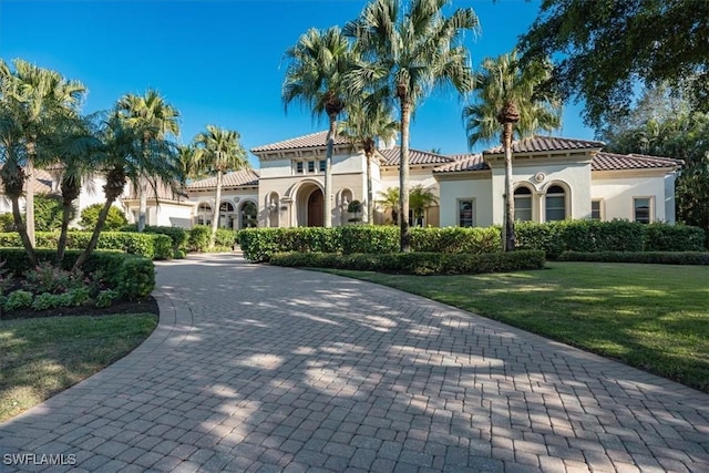 mediterranean / spanish-style house with a front yard