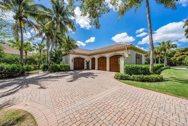 mediterranean / spanish home with a front yard and a garage