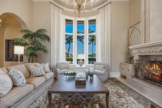 living room featuring a high end fireplace and a notable chandelier