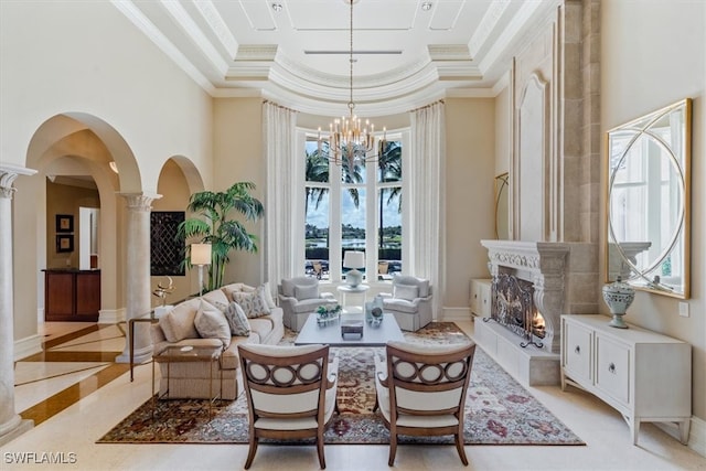 dining area with a notable chandelier, decorative columns, a towering ceiling, a tray ceiling, and ornamental molding