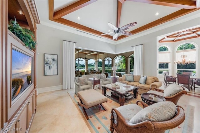 living room featuring ceiling fan with notable chandelier, plenty of natural light, ornamental molding, and a high ceiling