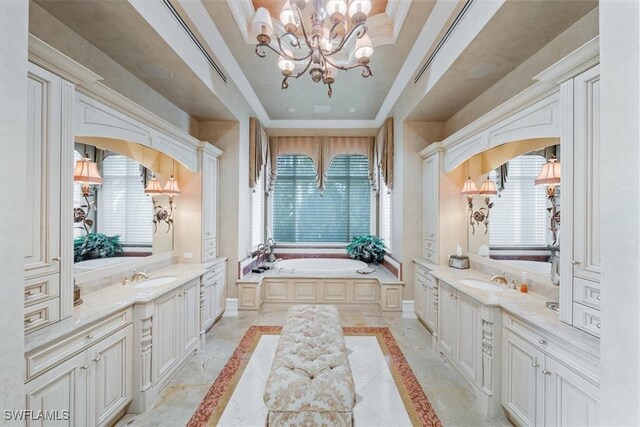 bathroom featuring a washtub, vanity, a chandelier, and a tray ceiling