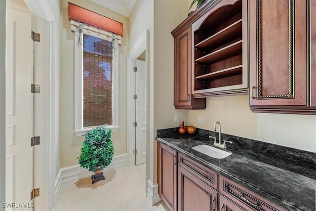 bar featuring sink and dark stone counters