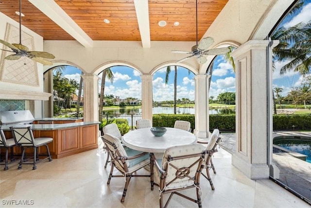 sunroom featuring ceiling fan, beam ceiling, a water view, and wooden ceiling