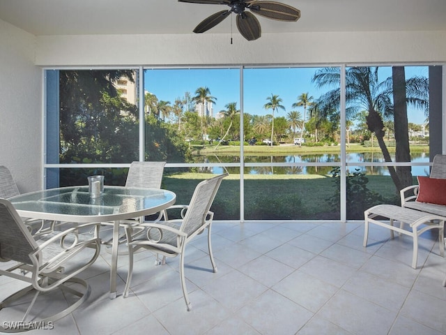 sunroom / solarium with ceiling fan, a water view, and a wealth of natural light