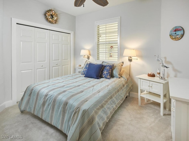 carpeted bedroom featuring ceiling fan and a closet