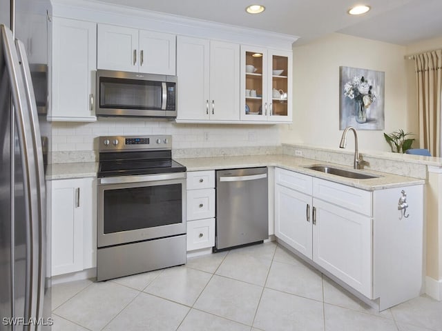 kitchen featuring decorative backsplash, sink, white cabinets, and stainless steel appliances