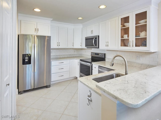 kitchen with sink, kitchen peninsula, light stone countertops, white cabinetry, and stainless steel appliances