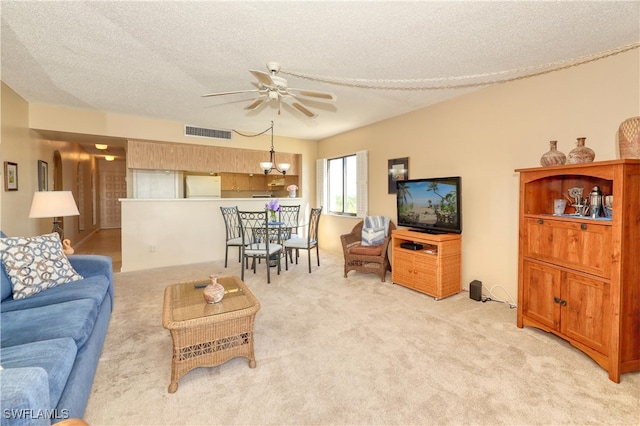 carpeted living room featuring ceiling fan with notable chandelier and a textured ceiling