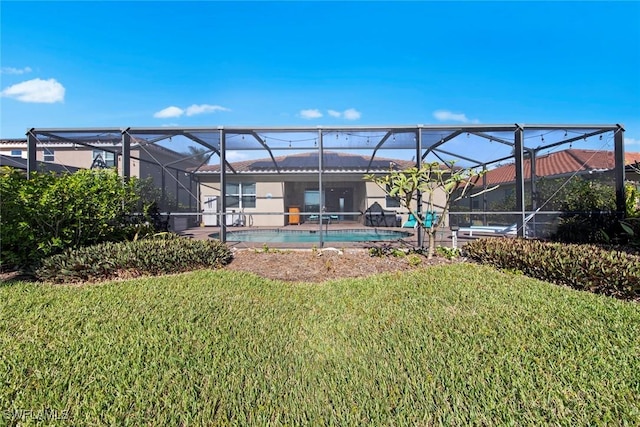 back of property with a lanai and a lawn