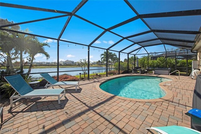 view of swimming pool featuring a lanai, a patio area, and a water view