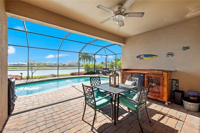 view of pool featuring a water view, a patio area, ceiling fan, and a lanai