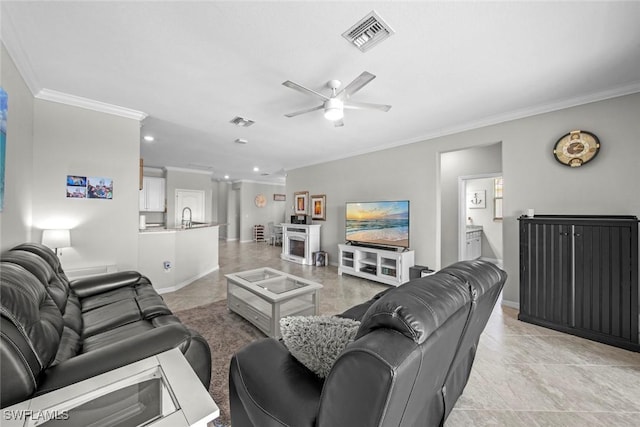 tiled living room with crown molding, sink, and ceiling fan