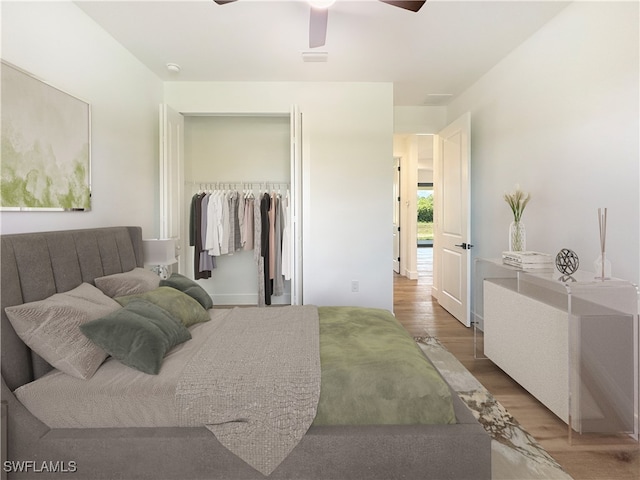 bedroom with ceiling fan, a closet, and wood-type flooring