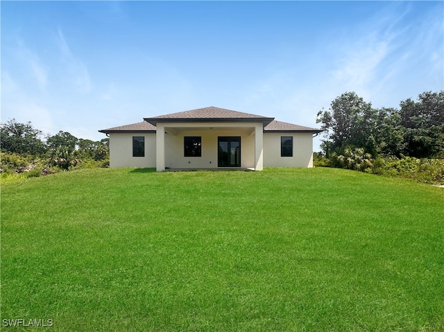 rear view of house featuring a lawn