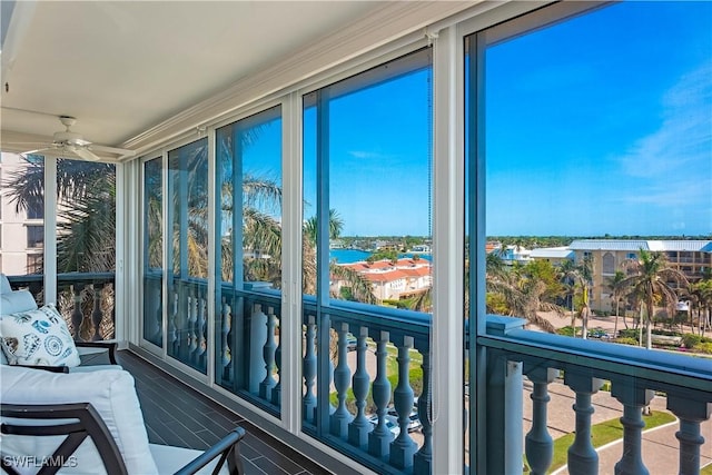 sunroom / solarium featuring a water view, ceiling fan, and a healthy amount of sunlight