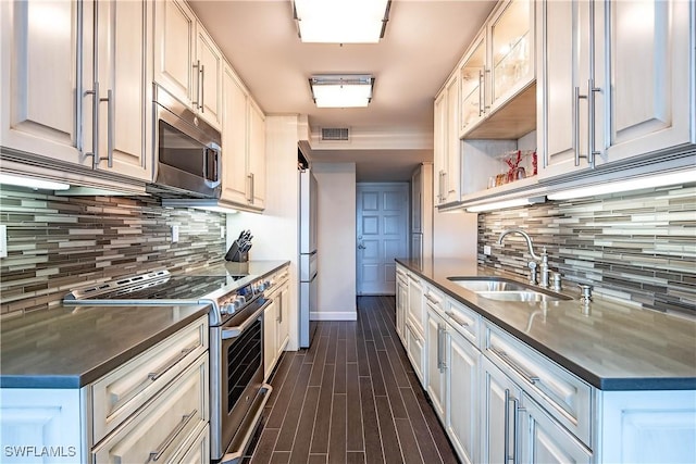 kitchen featuring decorative backsplash, sink, white cabinets, and appliances with stainless steel finishes