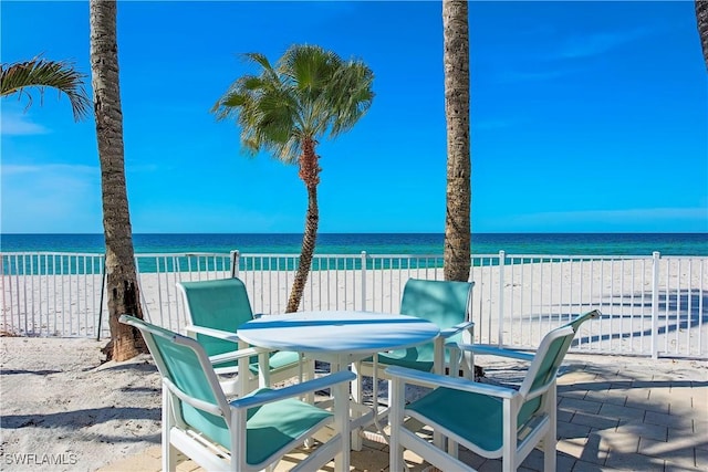 view of patio / terrace with a beach view and a water view