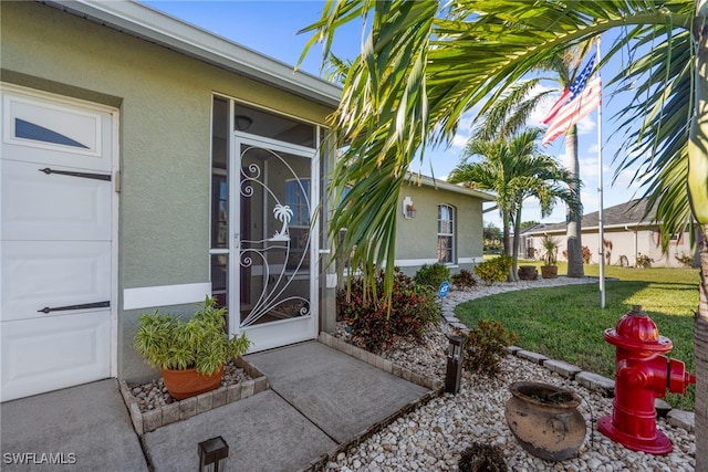 1744 SW 15th St, Cape Coral, FL 33991 - doorway to property featuring stucco siding and a yard