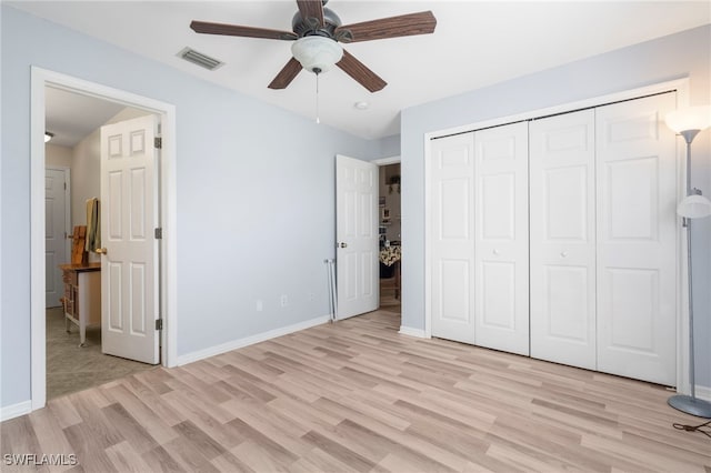 unfurnished bedroom featuring a closet, light hardwood / wood-style flooring, and ceiling fan