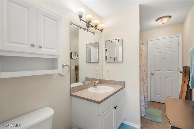 bathroom with tile patterned flooring, vanity, and toilet