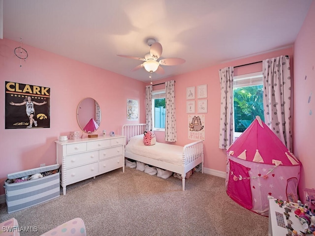 carpeted bedroom featuring multiple windows and ceiling fan