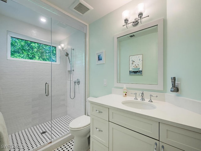 bathroom featuring tile patterned flooring, vanity, toilet, and an enclosed shower