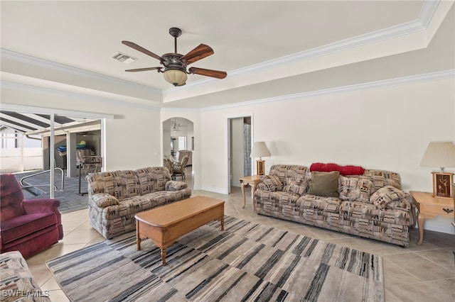 tiled living room with ceiling fan and crown molding