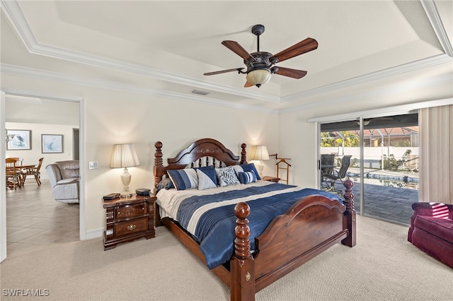 carpeted bedroom with access to exterior, a tray ceiling, ceiling fan, and ornamental molding