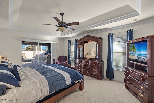 carpeted bedroom with a raised ceiling, ceiling fan, ornamental molding, and access to outside