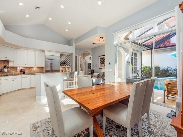 dining area with light tile patterned flooring and lofted ceiling