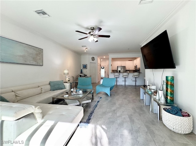 living room with crown molding and ceiling fan