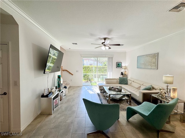 living room featuring ceiling fan, ornamental molding, and a textured ceiling