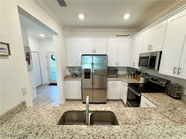 kitchen featuring light stone countertops, white cabinetry, sink, crown molding, and appliances with stainless steel finishes