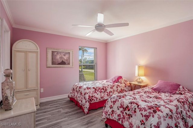 bedroom featuring ceiling fan, light hardwood / wood-style floors, and crown molding