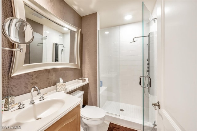 bathroom featuring tile patterned floors, vanity, toilet, and a shower with shower door