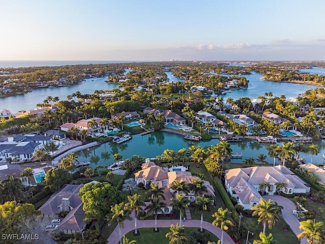 aerial view at dusk featuring a water view