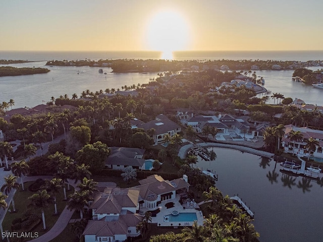 aerial view at dusk featuring a water view