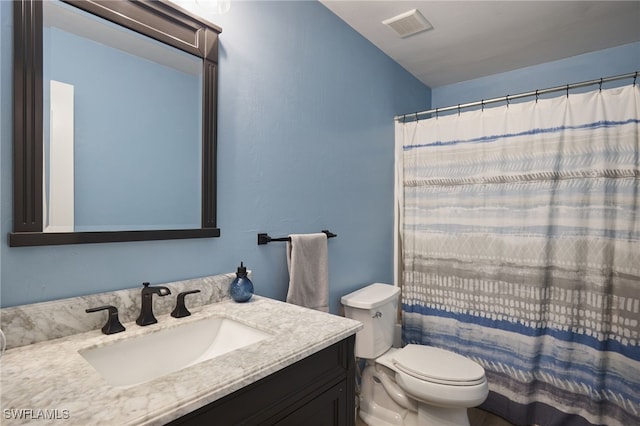 bathroom with vanity, toilet, and walk in shower