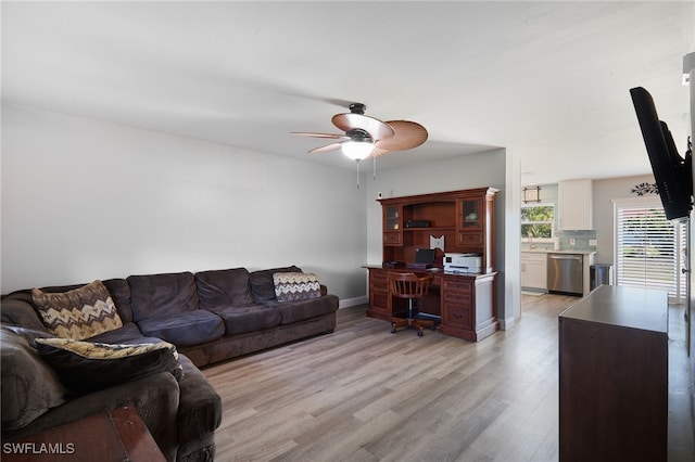 living room featuring light hardwood / wood-style flooring, ceiling fan, and sink