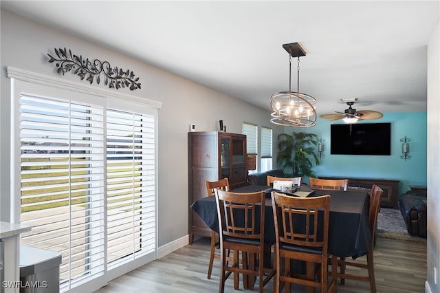 dining area featuring ceiling fan with notable chandelier and light hardwood / wood-style floors