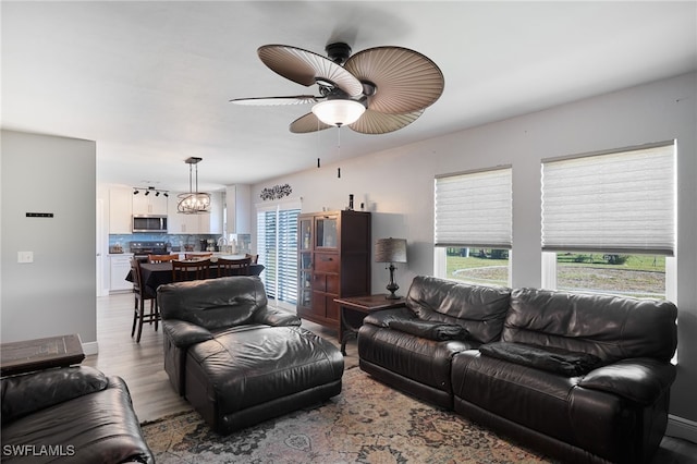 living room with ceiling fan and light wood-type flooring