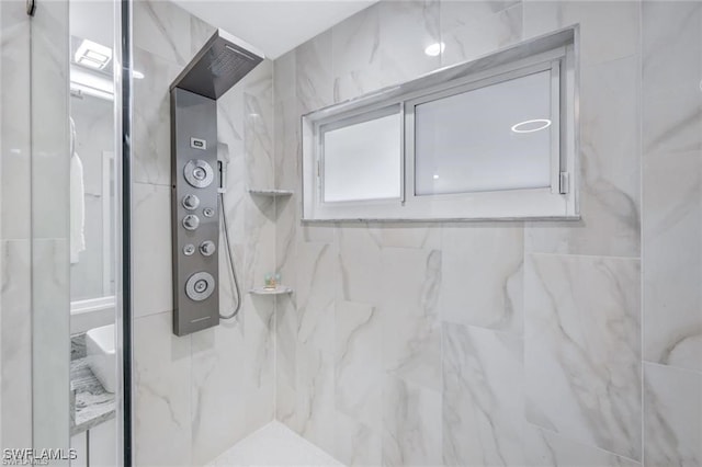 bathroom featuring a tile shower and tile walls